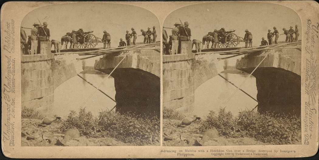 Advancing on Malolos with a Hotchkiss Gun over a Bridge destroyed by Insurgents, Philippines.